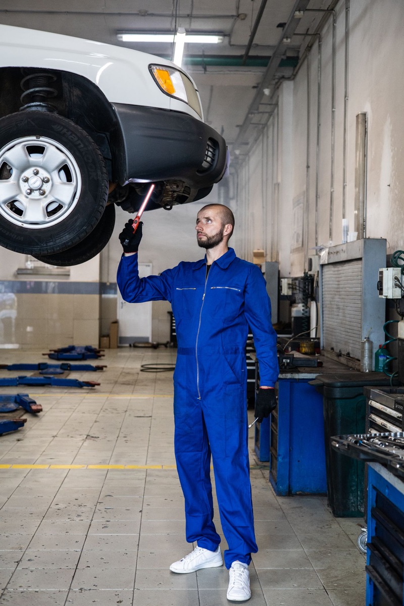 Mechanik sprawdza podwozie auta na podnośniku